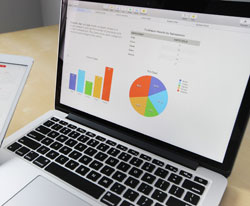 laptop computer showing bar graph and pie chart