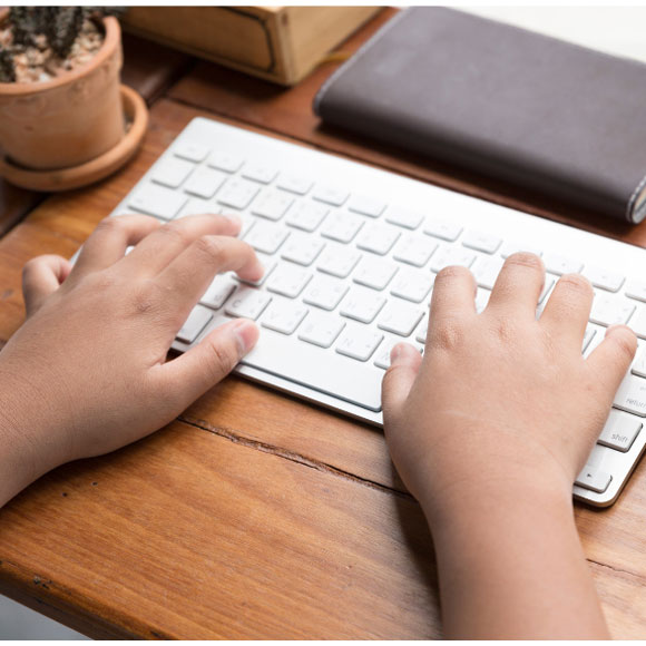 close-up of child's hands on a computer keyboard