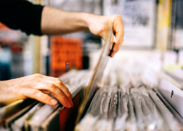 close-up photo of two hands pulling a file folder out of a large drawer of folders